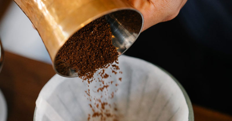 Barista toarnă apă fiartă peste dripper-ul de cafea filtru, gestul ritual al metodei pour-over în paletă caldă editorial